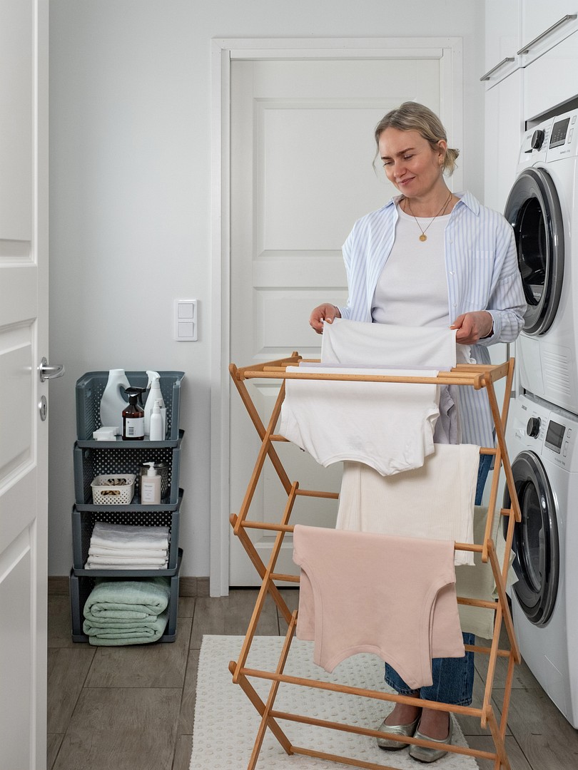 A woman doing laundry, SmartStore Essence Stack storage baskets in the background